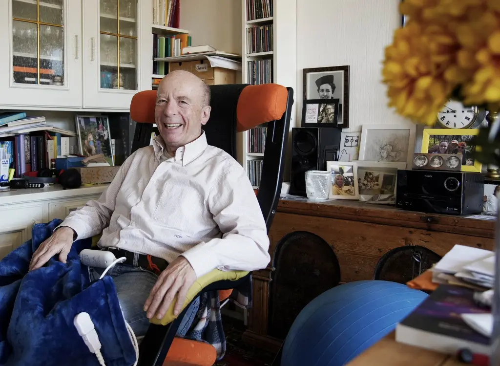 Ein Herr zufrieden im Lehnstuhl mit Heizdecke