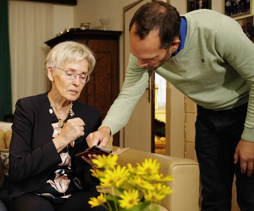 Geschäftsführer von Paula erklärt Seniorin, wie man die Paula-App am Smartphone nutzt