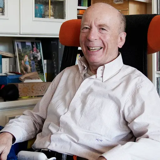 Älterer Herr mit Lächeln im Gesicht zuhause im Lieblingssessel